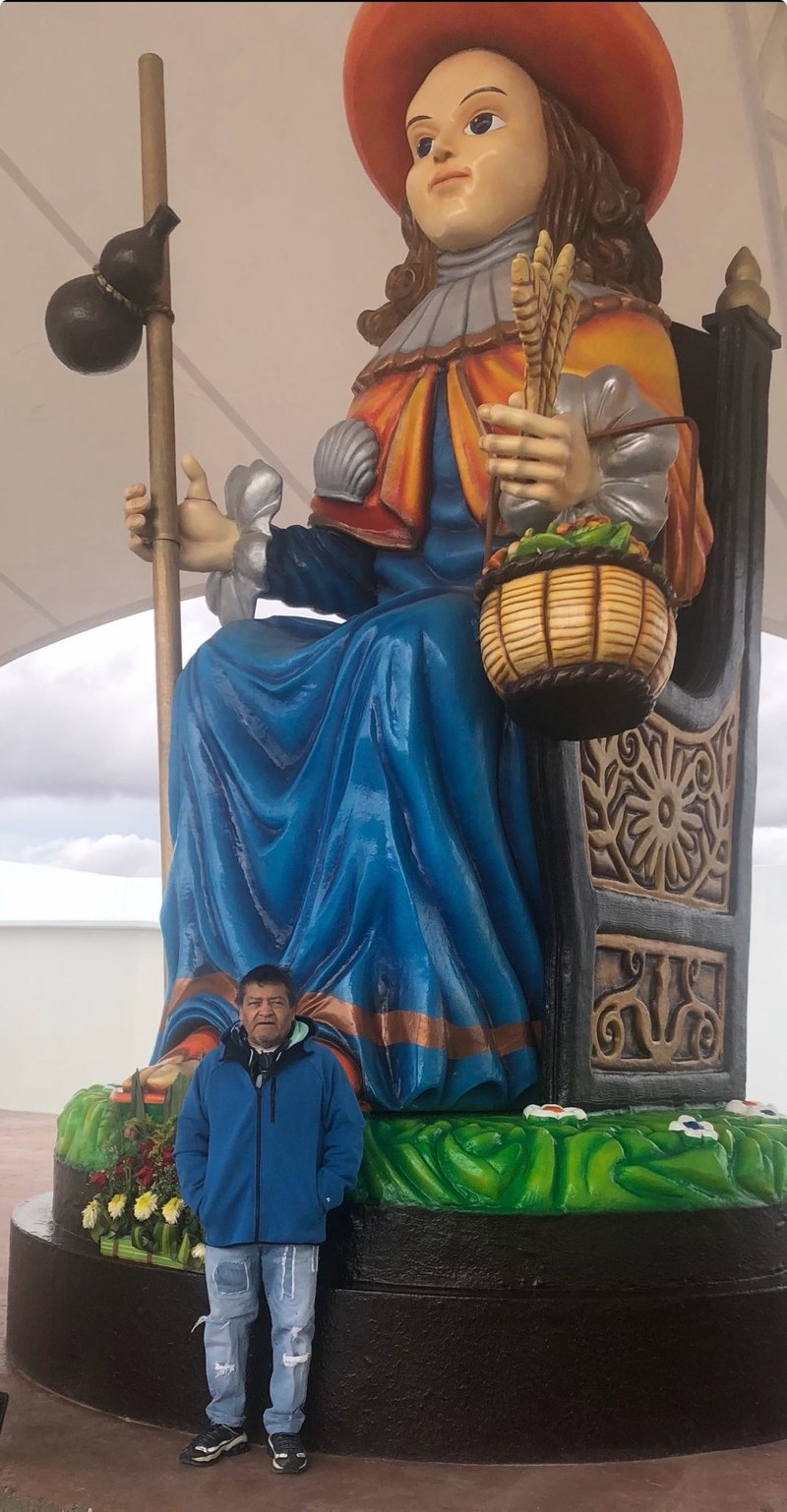Efren Mireles standing at the foot of a statue of the Santo Niño de Atocha